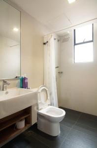 y baño con aseo, lavabo y espejo. en Holiday Homes At Samsuria Resort en Kampung Sungai Ular