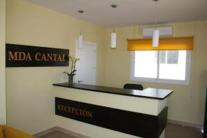 a reception desk in a office with a sign on the wall at Mda Playa del Cantal in Mojácar