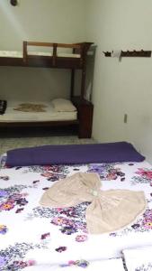 a bedroom with a bed with a flowery blanket and bunk beds at Pousada Catavento in Piraí