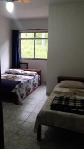 a bedroom with two beds and a window at Pousada Catavento in Piraí