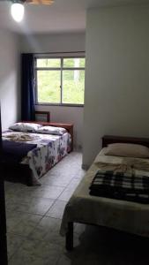 Un dormitorio con dos camas y una ventana. en Pousada Catavento, en Piraí