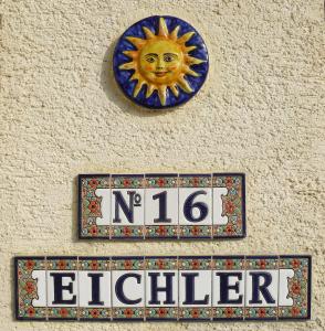 eine blaue Platte mit einer Sonne und einem Schild an der Wand in der Unterkunft Ferienwohnung Eichler in Feldkirchen in Kärnten