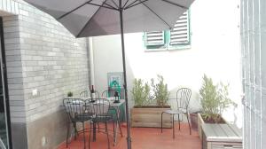 a patio with a table and chairs and an umbrella at Veracini apartment in Florence