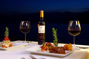 a bottle of wine and two plates of food and wine glasses at Lukka Exclusive Hotel – Adult Only +12 in Kaş