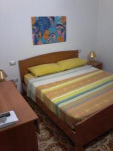 1 dormitorio con 1 cama, 1 mesa y 1 pintura en B&B Sea And Sardinia, en Alghero