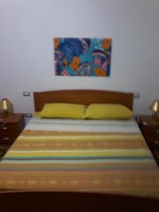 1 dormitorio con 1 cama con una pintura en la pared en B&B Sea And Sardinia, en Alghero
