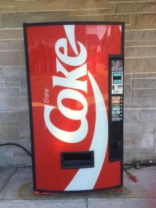 a coca cola vending machine on the side of a building at Pinconning Trail Inn Motel in Pinconning