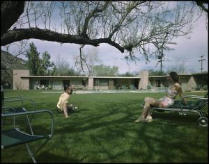 a man and a woman sitting on a bench in the grass at The Hideaway in Palm Springs