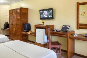 a room with a desk and a laptop on a table at Porto Cálem Praia Hotel in Porto Seguro