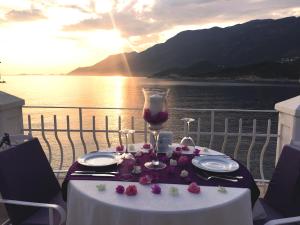a table with a glass of wine and flowers on it at Lukka Exclusive Hotel – Adult Only +12 in Kaş