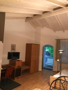 ein Wohnzimmer mit Holzdecken, einem Schreibtisch und einer Tür in der Unterkunft Hotel Korfu in Geiselhöring