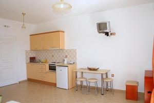 a kitchen with a table and stools in a room at Alkioni Studios in Trapezaki