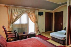 een hotelkamer met een bed en een raam bij Gold Hotel in Korçë