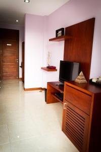 a living room with a tv on a wooden desk at Melasa House in Senggigi 