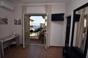 um quarto com um espelho, uma mesa e uma varanda em B&B Paradiso Relais em Messina