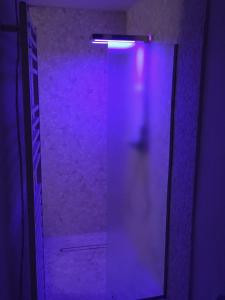 una luz púrpura brilla en una nevera en una habitación en Suite Romantica Fuga, en Roncone