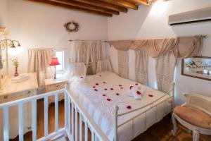 Un dormitorio con una cama con rosas. en Peristeronas house sifnos - Dove Cot sifnos, en Apollonia
