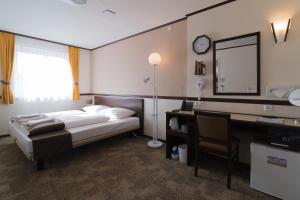 a bedroom with a bed and a desk and a mirror at Toyoko Inn Frankfurt am Main Hauptbahnhof in Frankfurt/Main