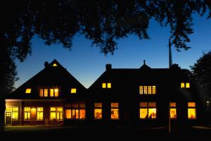 a house with its lights on at night at Landhuis Hotel Rikus in Eext