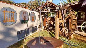 una exposición de un parque infantil con una rueda de madera en Pousada Maktub, en Guarda do Embaú