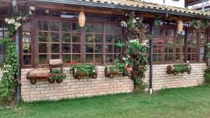 un invernadero con plantas y flores en un edificio en Pousada Maktub, en Guarda do Embaú