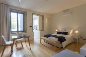 una camera da letto con un letto, un tavolo e una scrivania di Casa da Figueiroa a Porto