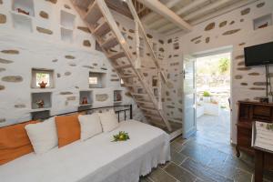 a bedroom with a white bed and a staircase at Peristeronas house sifnos - Dove Cot sifnos in Apollonia