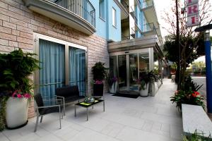 een patio buiten een gebouw met stoelen en een tafel bij Hotel Capri in Bellaria-Igea Marina