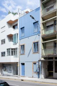 ein weißes Apartmenthaus mit Straßenbeleuchtung in der Unterkunft Casa da Figueiroa in Porto