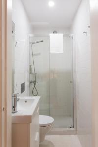 a white bathroom with a shower and a toilet at Casa da Figueiroa in Porto +32 photos