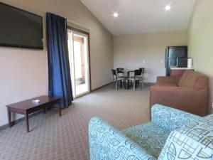 a living room with a couch and a tv at Edgewater Hotel and Suites in Put-in-Bay