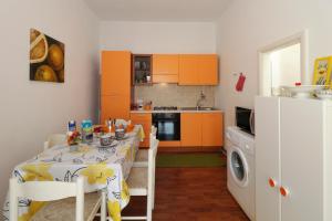ドンナルカータにあるLa Casa di Marioのキッチン(テーブル付)、キッチン(オレンジ色のキャビネット付)