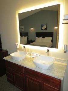 a bathroom with two sinks and a large mirror at Edgewater Hotel and Suites in Put-in-Bay