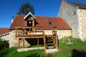 a wooden play structure in front of a building at Le Clos du Val in Chivres-Val