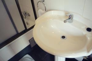- Baño con lavabo blanco y ducha en HelChiloé Aparthotel, en Castro
