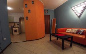 an orange column in a living room with a couch and a table at Rooms on Pirogova in Saint Petersburg