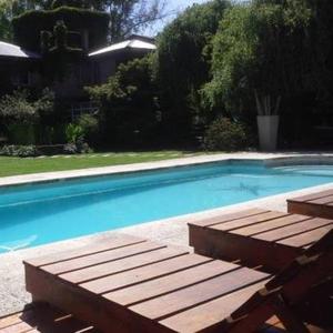 a swimming pool with a wooden bench next to it at La Ignacia Bed and Breakfast in Pilar