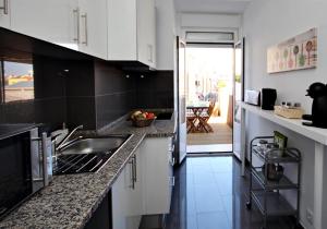 eine Küche mit weißen Schränken und einer Arbeitsplatte in der Unterkunft Lisbon Lights Apartments in Lissabon