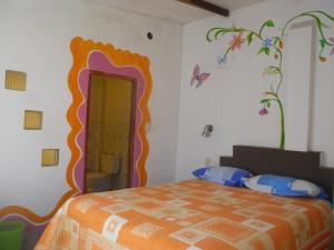 una camera da letto con un letto e un murale floreale sul muro di Hostal La Casa del Sol a Copacabana