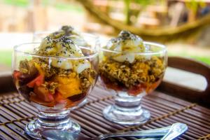 three glasses of ice cream on a table at Caju Bangalôs in Ponta do Anel