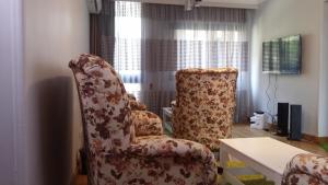 a living room with a chair and a table at Khayatz Apartment in Cairo