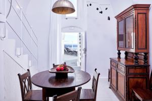 a dining room table and chairs in a kitchen at Cosmopolitan Suites - Small Luxury Hotels of the World in Fira