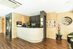 a lobby with a counter and a kitchen with a counter at Fragrance Hotel - Viva in Singapore +9 photos