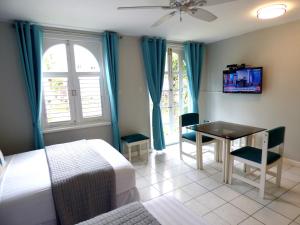 a bedroom with a bed and a table and a tv at Beach Studio 4 in Ocho Rios