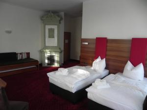 een hotelkamer met 2 bedden en een piano bij Hotel Schwibbogen Görlitz in Görlitz