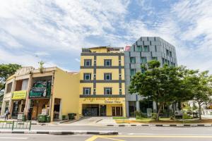 a tall yellow building on a city street at Fragrance Hotel - Ocean View in Singapore