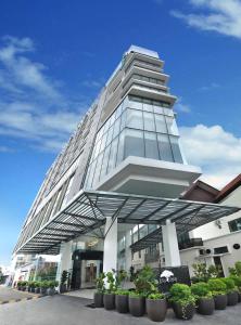 un edificio alto con plantas delante en Eco Tree Hotel, Melaka, en Melaka