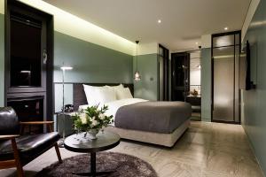 a bedroom with a bed and a couch and a table at 9 Brick Hotel in Seoul +30 photos