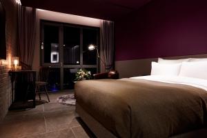 a bedroom with a bed and a table and a window at 9 Brick Hotel in Seoul