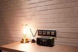 a table with a lamp and a clock and a radio at 9 Brick Hotel in Seoul
